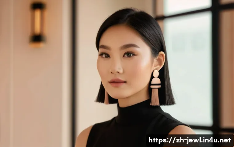귀걸이의 길이별 스타일링 팁 - A stylish Asian woman with a round face wearing long, slender tassel earrings featuring subtle geome...