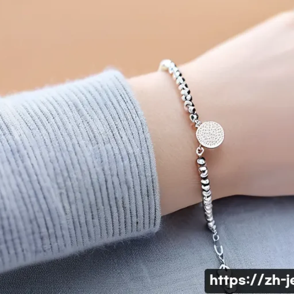 손목 사이즈에 맞는 팔찌 선택법 - A delicate wrist adorned with a fine, lightweight silver chain bracelet featuring tiny beads and a s...