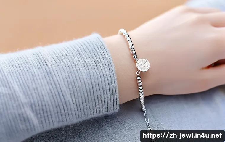 손목 사이즈에 맞는 팔찌 선택법 - A delicate wrist adorned with a fine, lightweight silver chain bracelet featuring tiny beads and a s...
